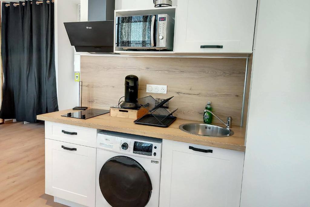 uma cozinha com uma máquina de lavar roupa e um lavatório em Magnifique studio hyper centre gare 2pers wifi em Saint-Quentin