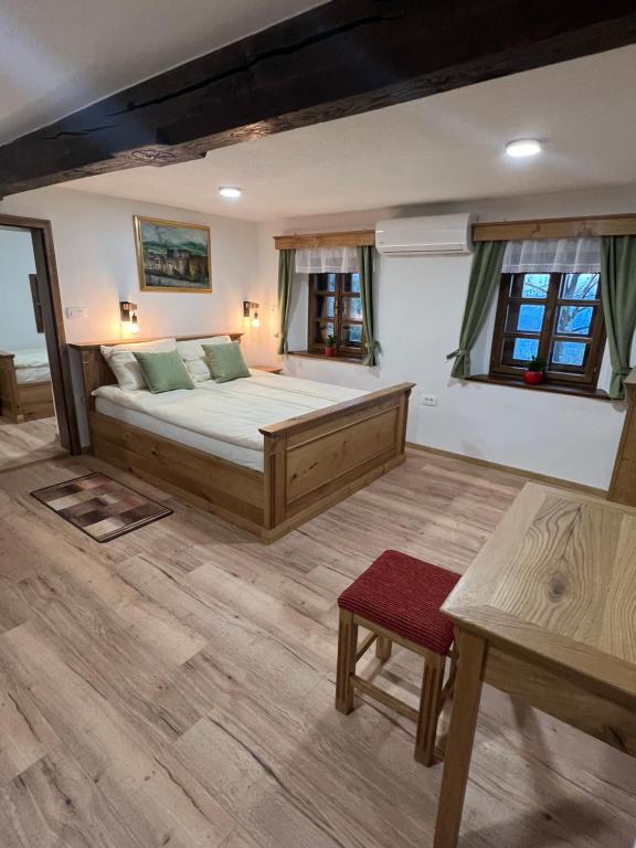 1 dormitorio con cama, mesa y ventanas en Boutique Tourist Farm Hrovat, en Frankolovo