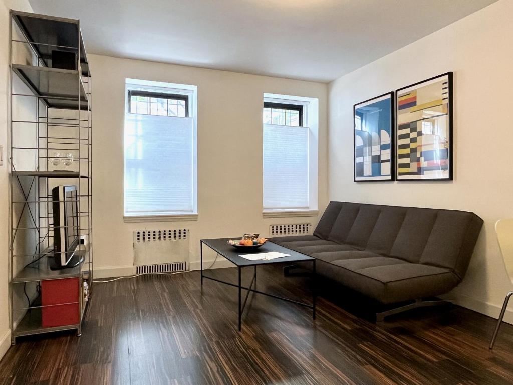 uma sala de estar com um sofá e uma mesa em Close to all! 2-room suite in a 1-family townhouse em Brooklyn