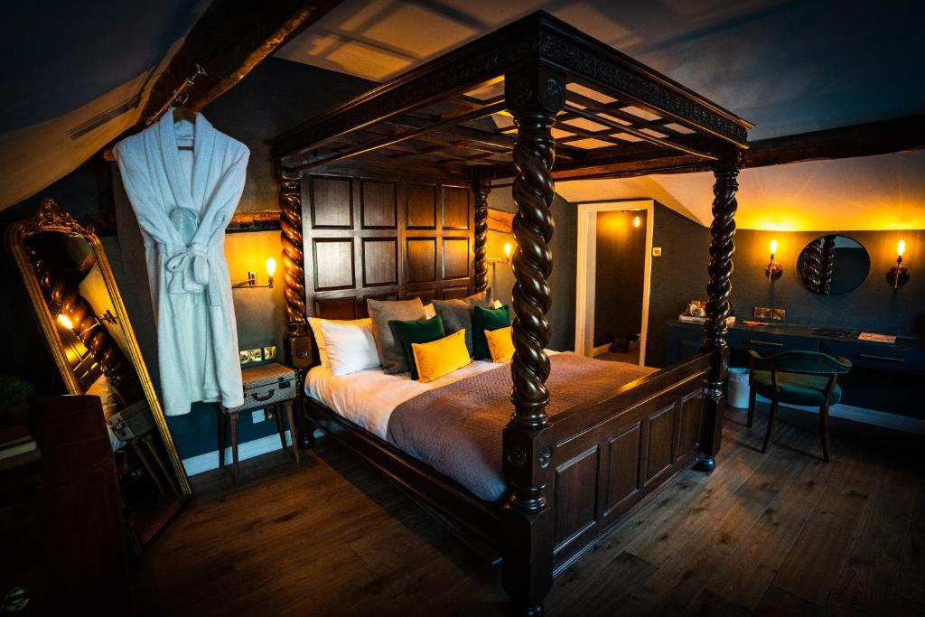 een slaapkamer met een hemelbed met gele kussens bij The Bridge in Macclesfield