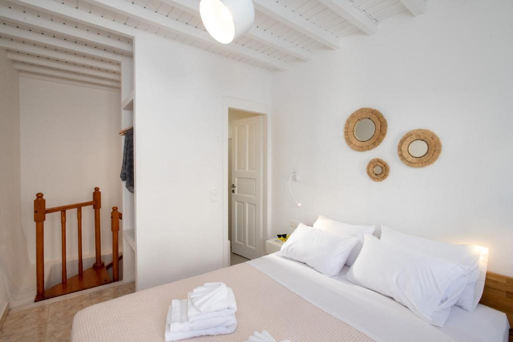 Dormitorio blanco con cama blanca y almohadas blancas en MYKONOS HOUSE Eternity maisonette , Mykonos Town en Mykonos