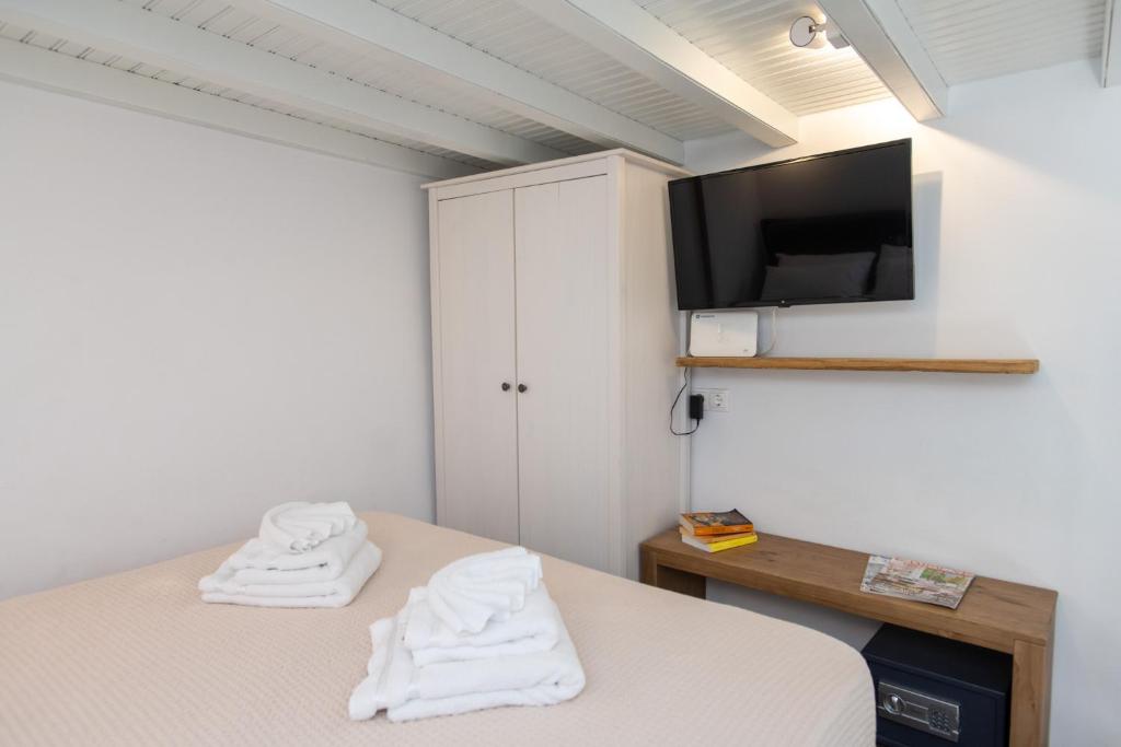 sypialnia z łóżkiem i telewizorem na ścianie w obiekcie MYKONOS HOUSE Aurora , Mykonos Town w mieście Mykonos