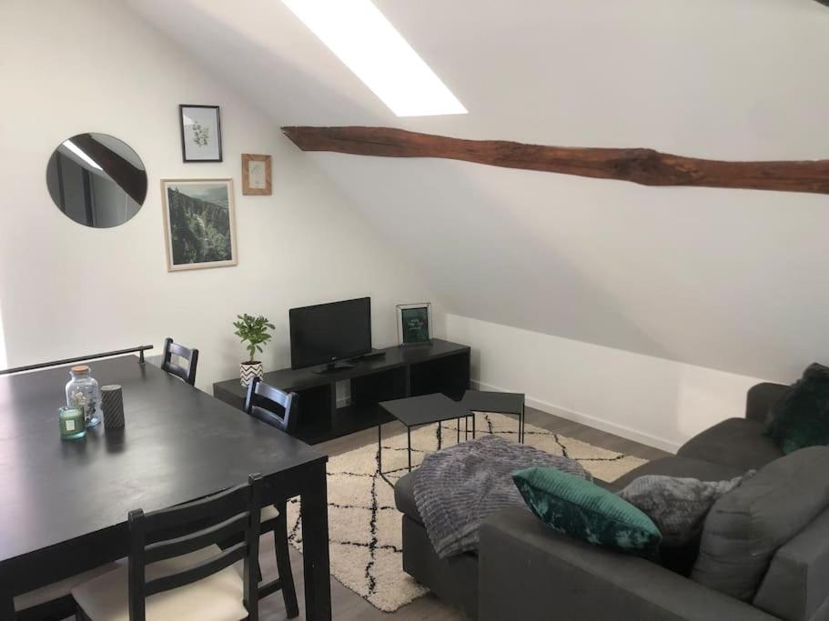 salon z kanapą i stołem jadalnym w obiekcie Le petit cloître w mieście Langres