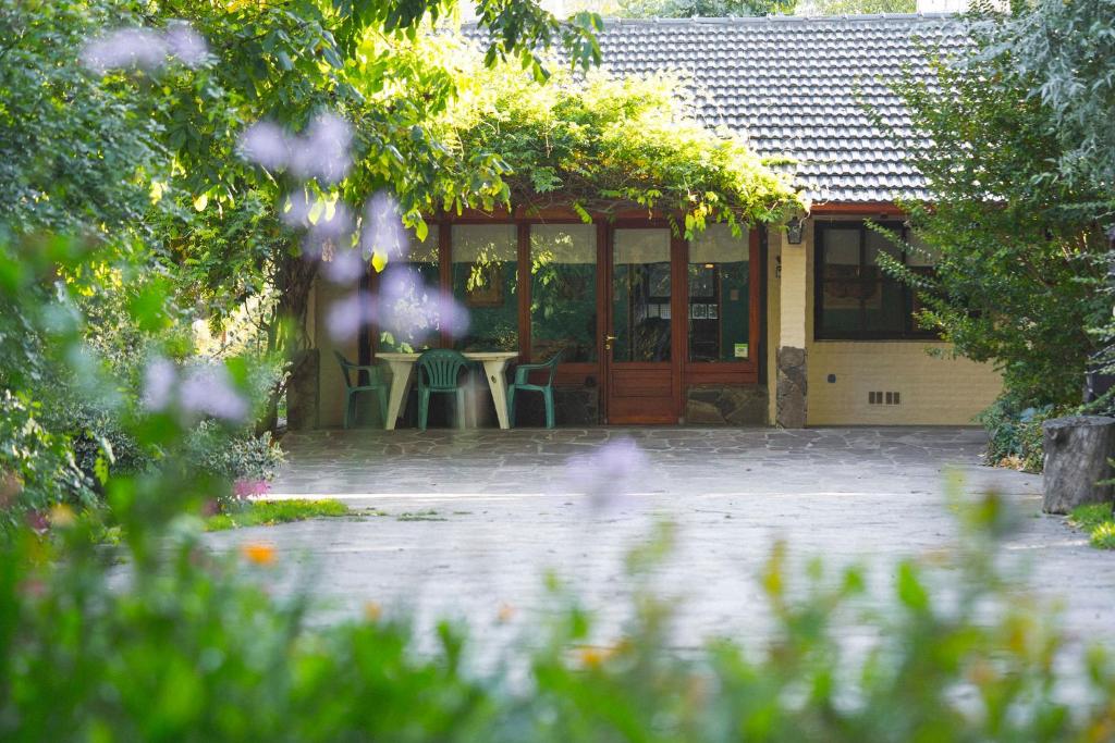 Casa con porche con mesa y sillas en El Colibrí Cabañas de la Naturaleza en Trelew