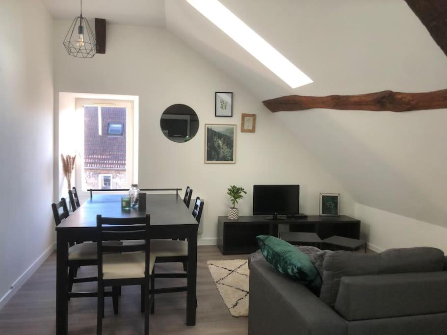 salon ze stołem i kanapą w obiekcie Le petit cloître w mieście Langres
