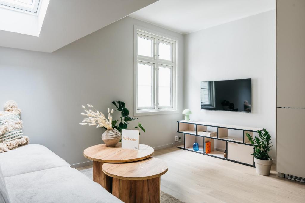 ein Wohnzimmer mit einem weißen Sofa und einem TV in der Unterkunft Stay Fløyen in Bergen