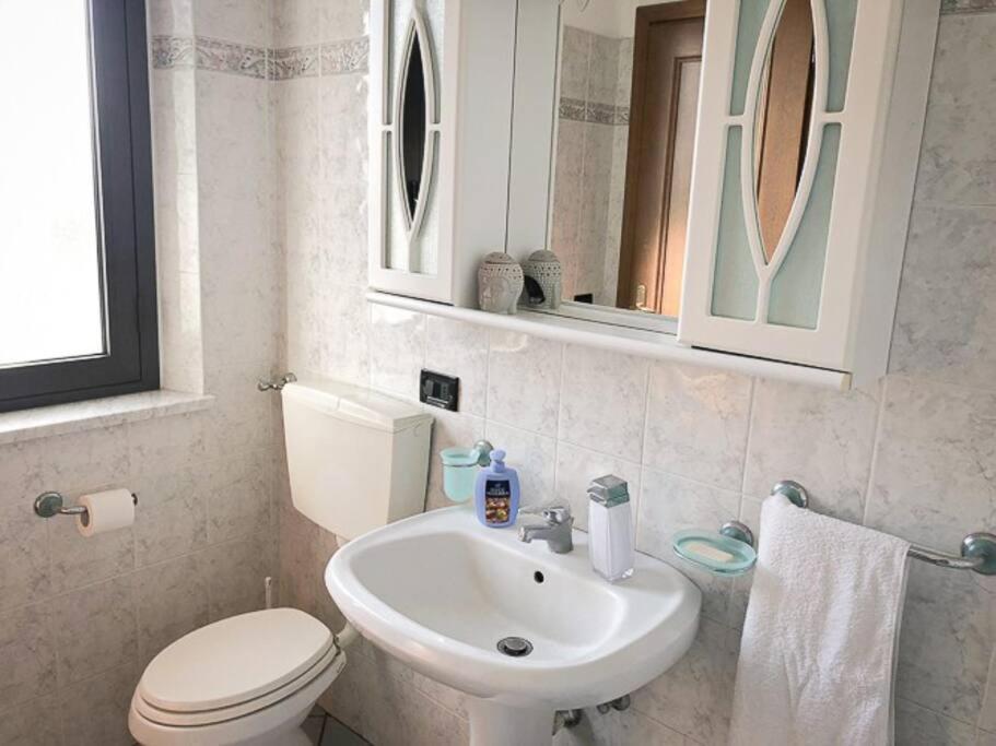 Łazienka z białą toaletą i umywalką w obiekcie Vinciguerra Central House Tuscany w mieście Altopascio