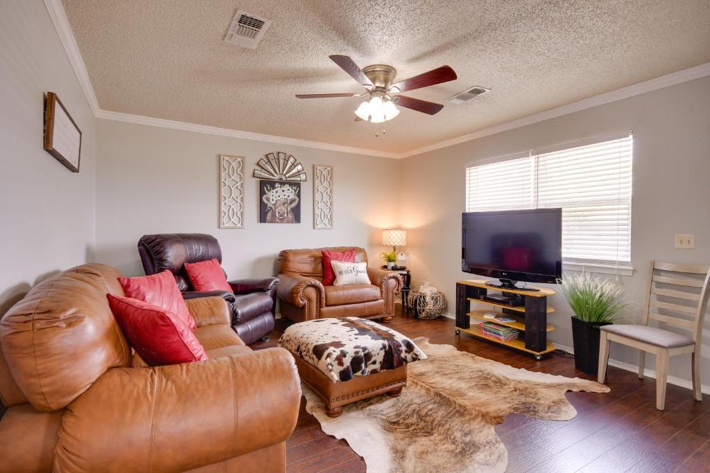 a living room with leather furniture and a flat screen tv at Pet-Friendly Vacation Rental with Yard in Canyon in Canyon