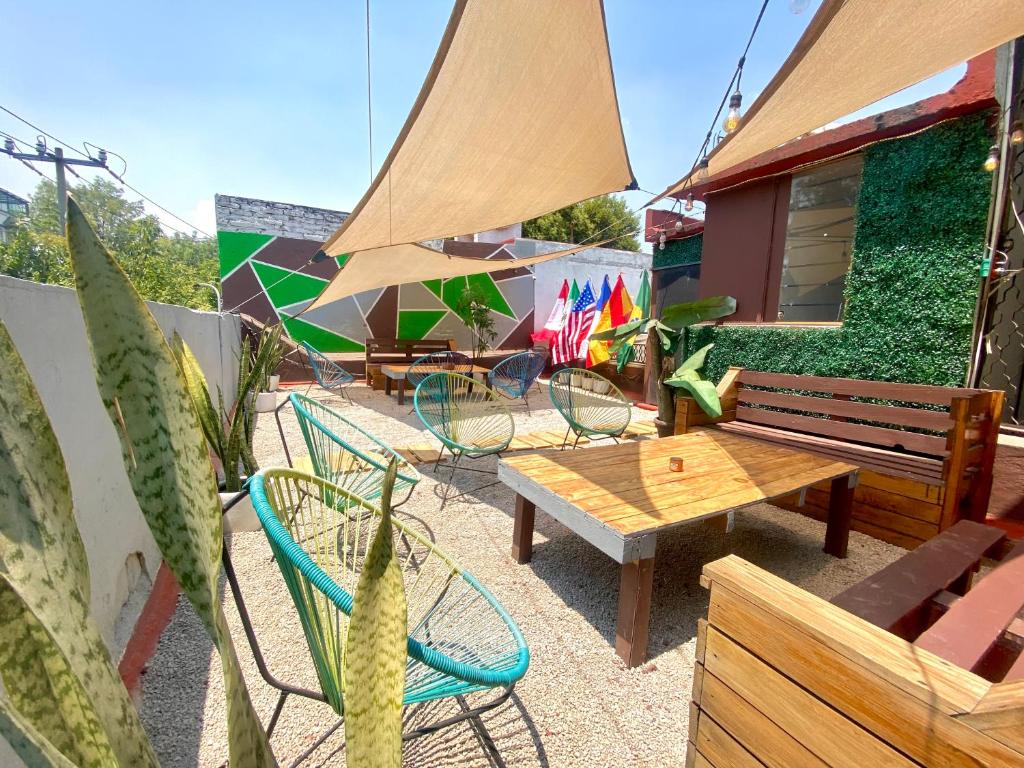 a patio with chairs and tables and a bench at ROOMIES HOSTEL Condesa in Mexico City
