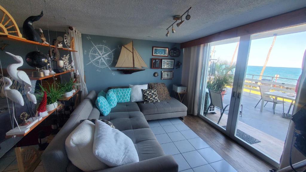 a living room with a couch and a view of the ocean at NAÜTIK, Ocean Front! Great view in Fajardo