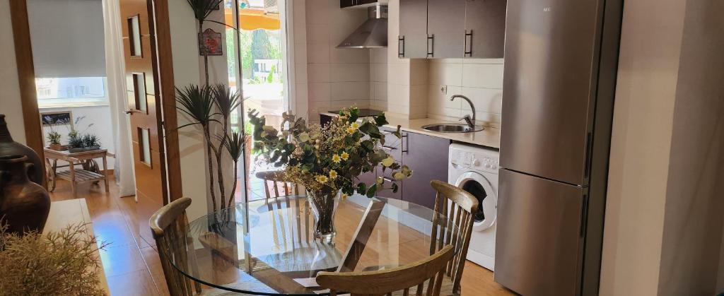 eine Küche mit einem Glastisch mit Stühlen und einem Kühlschrank in der Unterkunft Apto Valentina Salou in Salou