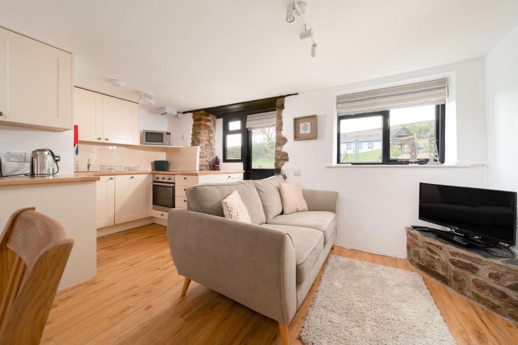 a living room with a couch and a kitchen at Kingfisher Cottage at Robin Hill 4 in Bideford