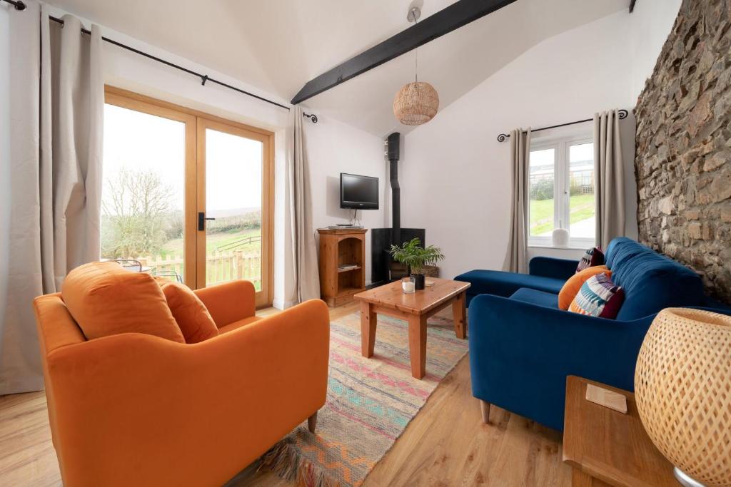 比迪福德的住宿－Wren Cottage at Robin Hill 4，客厅配有2张蓝色沙发和电视