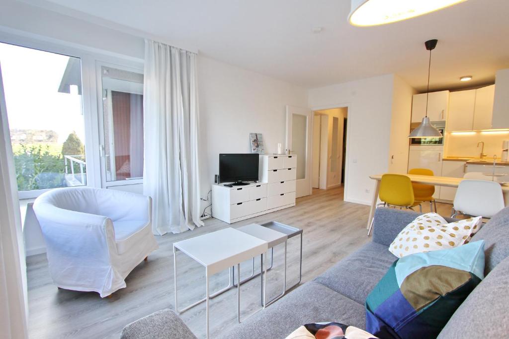 ein Wohnzimmer mit einem Sofa und einem Tisch in der Unterkunft Hanseat II App 102 inkl Strandkorb in Grömitz