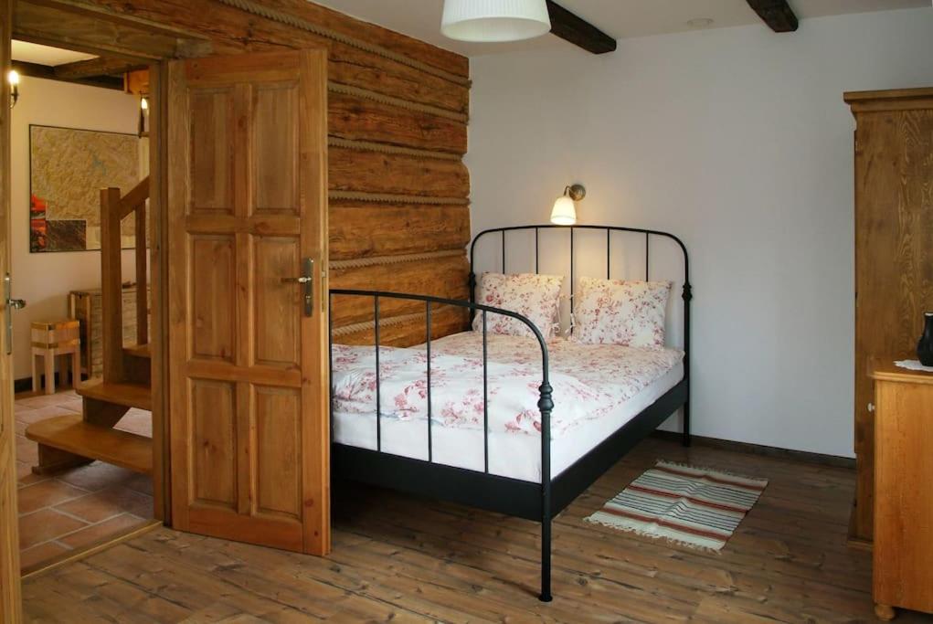 - une chambre avec un lit et une porte en bois dans l'établissement Chata Sanna, à Lesko