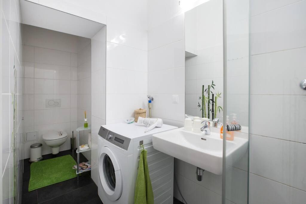 a bathroom with a washing machine and a sink at Relax Apartment Vienna City Center in Vienna