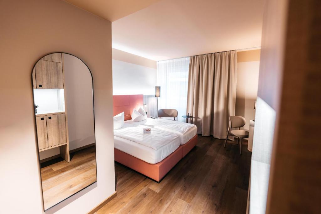 a hotel room with a bed and a mirror at City Park Hotel in Frankfurt Oder