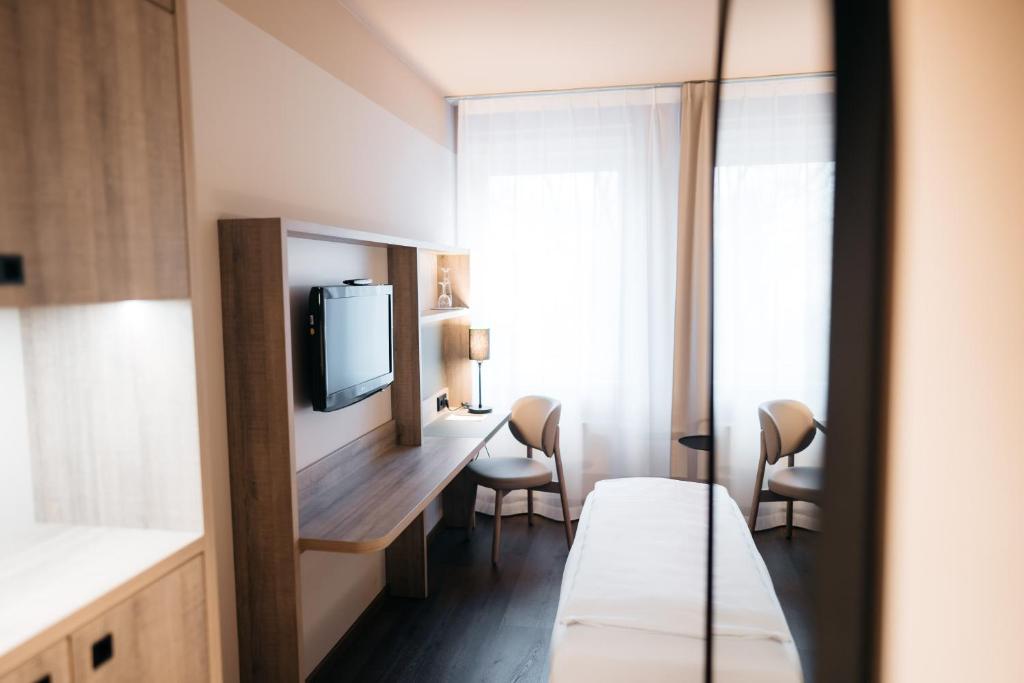 a hotel room with a bed and a desk with a tv at City Park Hotel in Frankfurt Oder