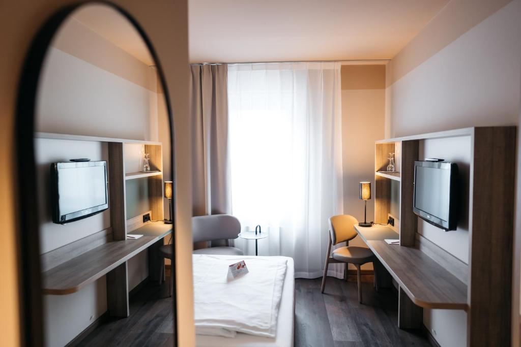 a hotel room with a bed and a mirror at City Park Hotel in Frankfurt Oder