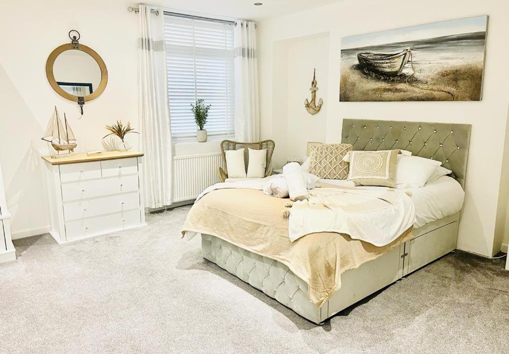 a bedroom with a bed and a mirror and a window at Seafront Apartment in Portsmouth