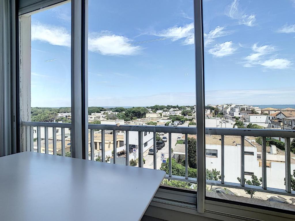 une table blanche devant une grande fenêtre dans l'établissement Studio Cabine Rénové Près Plage avec Parking Privé - FR-1-715-34, à Mauguio