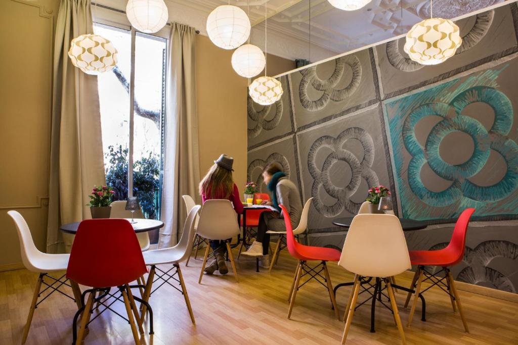 um restaurante com cadeiras vermelhas e pessoas sentadas à mesa em Born Barcelona Hostel em Barcelona