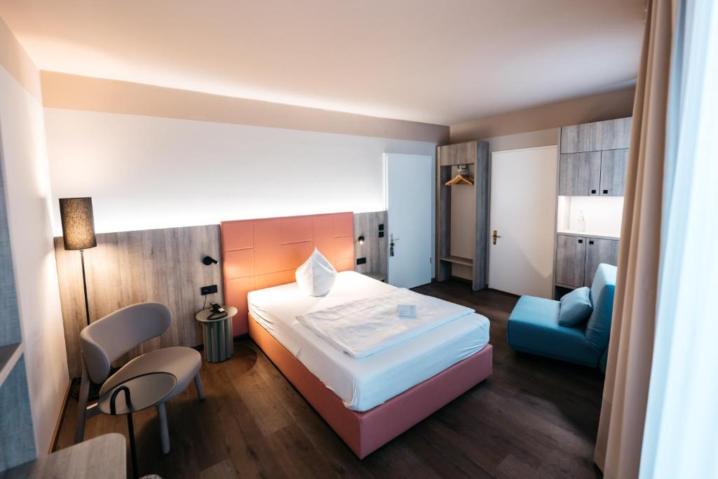 a hotel room with a bed and a blue chair at City Park Hotel in Frankfurt Oder