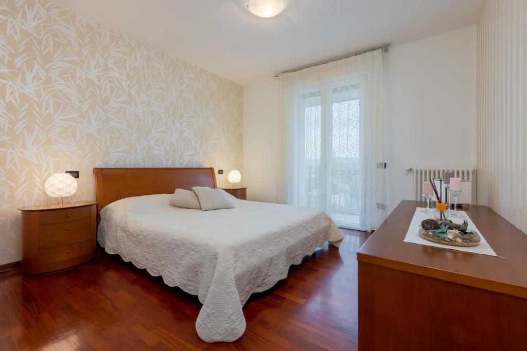 een slaapkamer met een bed, een dressoir en een raam bij GIOTTO Guesthouse in Due Carrare