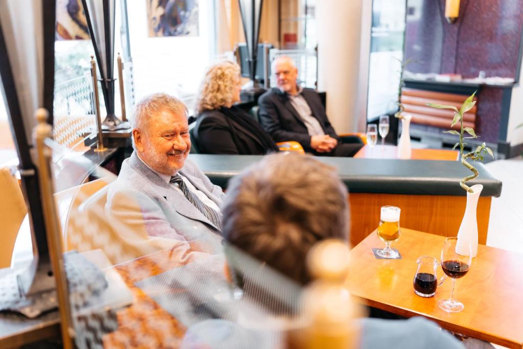 a group of people sitting at a table in a restaurant at City Park Hotel in Frankfurt Oder