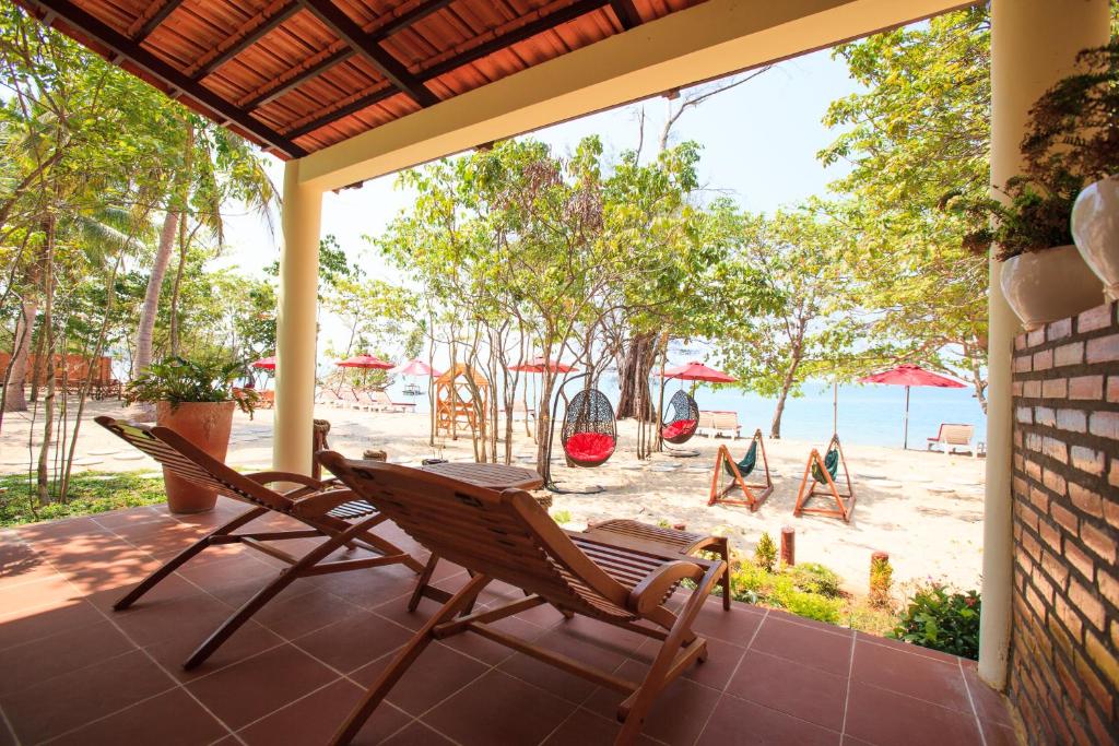 
a patio area with chairs, tables and umbrellas at Wild Beach Phu Quoc Resort in Phú Quốc
