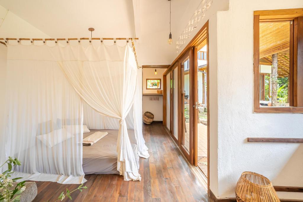 Schlafzimmer mit einem Bett mit Moskitonetz in der Unterkunft Casa do Jardim in Serra Grande
