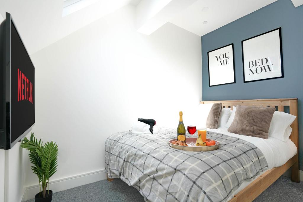 a bedroom with a bed with a tray of wine bottles at Central Buckingham Apartment #4 with Free Parking, Pool Table, Fast Wifi and Smart TV with Netflix by Yoko Property in Buckingham