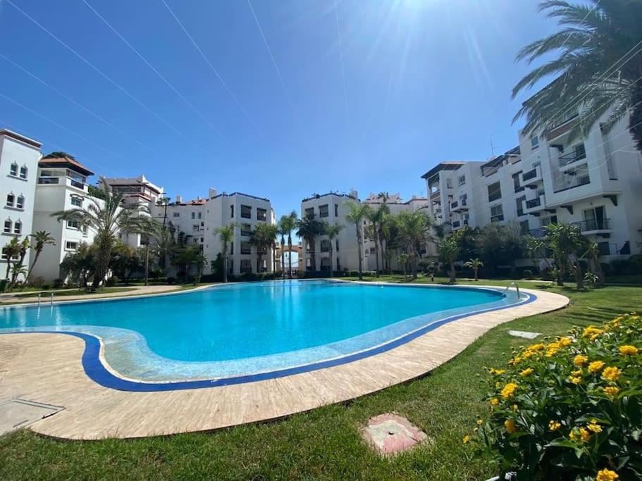 a large swimming pool in a yard with buildings at Marina Agadir - Luxury Pool view apartment 2Bdr in Agadir