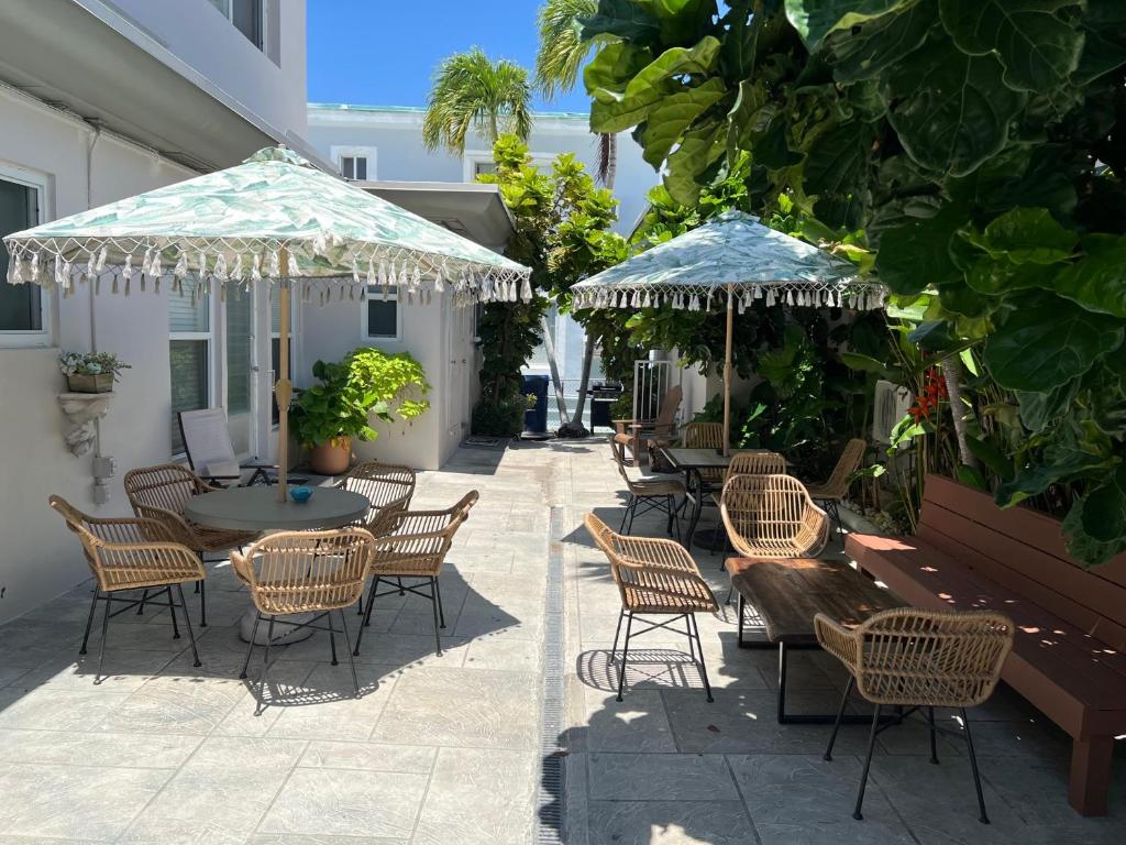 eine Terrasse mit Stühlen, Tischen und Sonnenschirmen in der Unterkunft Tiana Beach Inn in Hollywood Beach