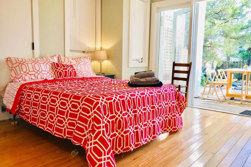 een slaapkamer met een bed met een rood en wit dekbed bij Cozy Poolside Studio in Durham