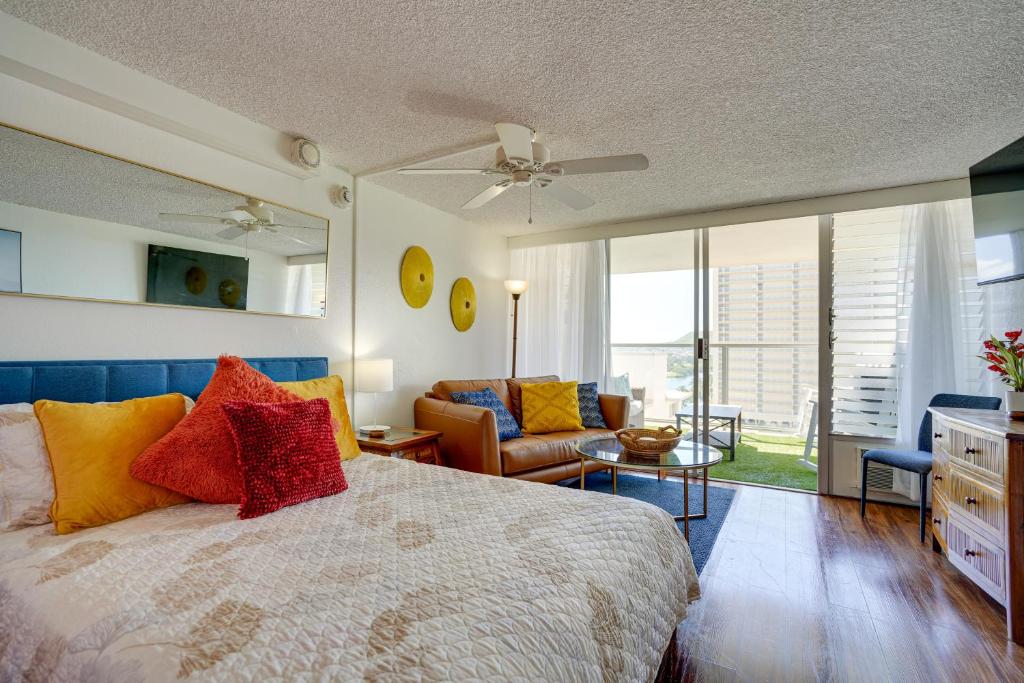 een slaapkamer met een bed met kleurrijke kussens bij Vibrant Studio in the Heart of Waikiki! in Honolulu