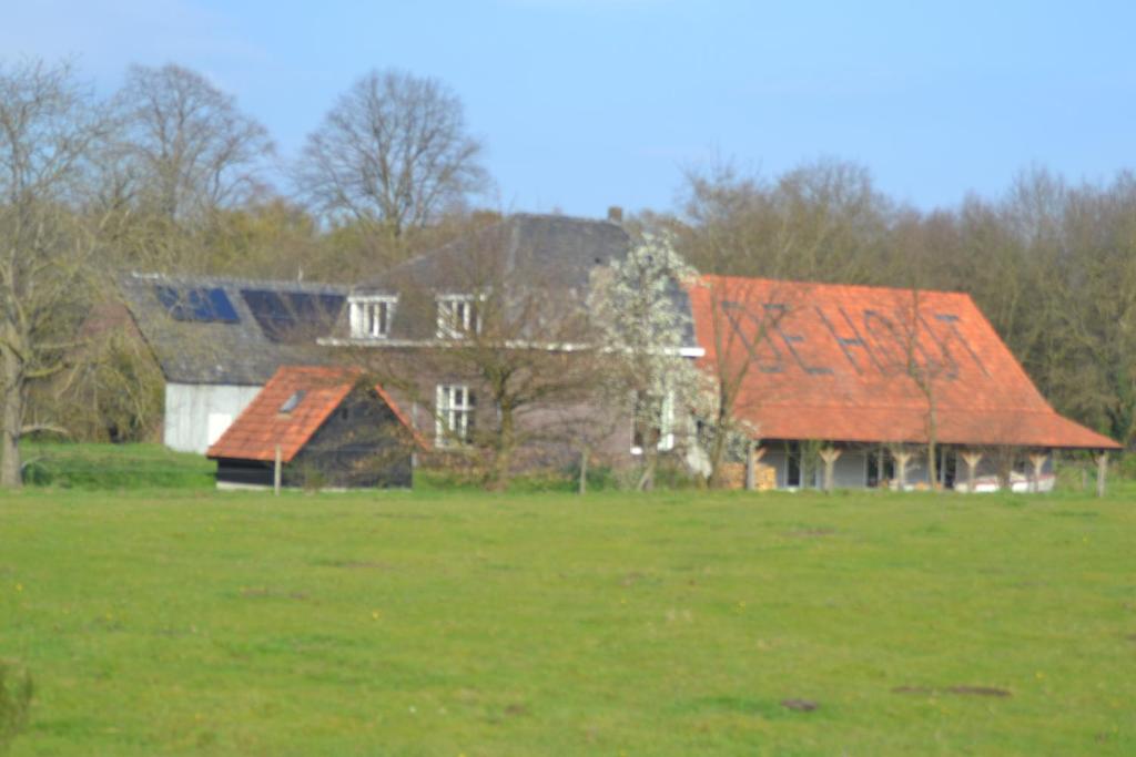 een oud huis met een rood dak in een veld bij Houterhoeve in Swalmen