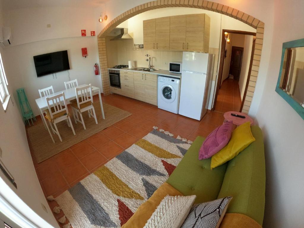 Il dispose d'une cuisine et d'un salon avec un canapé et une table. dans l'établissement Algarve, renovated T1 apartment in S Bras de Alportel, à São Brás de Alportel
