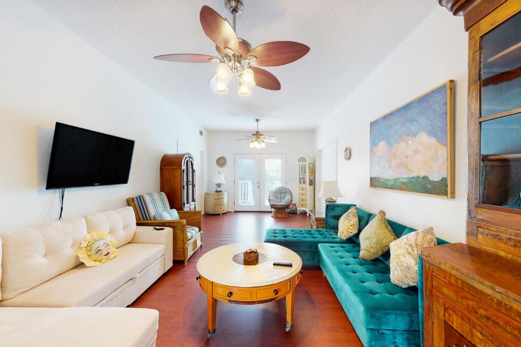 a living room with a couch and a ceiling fan at Abaco House in Gulf Shores