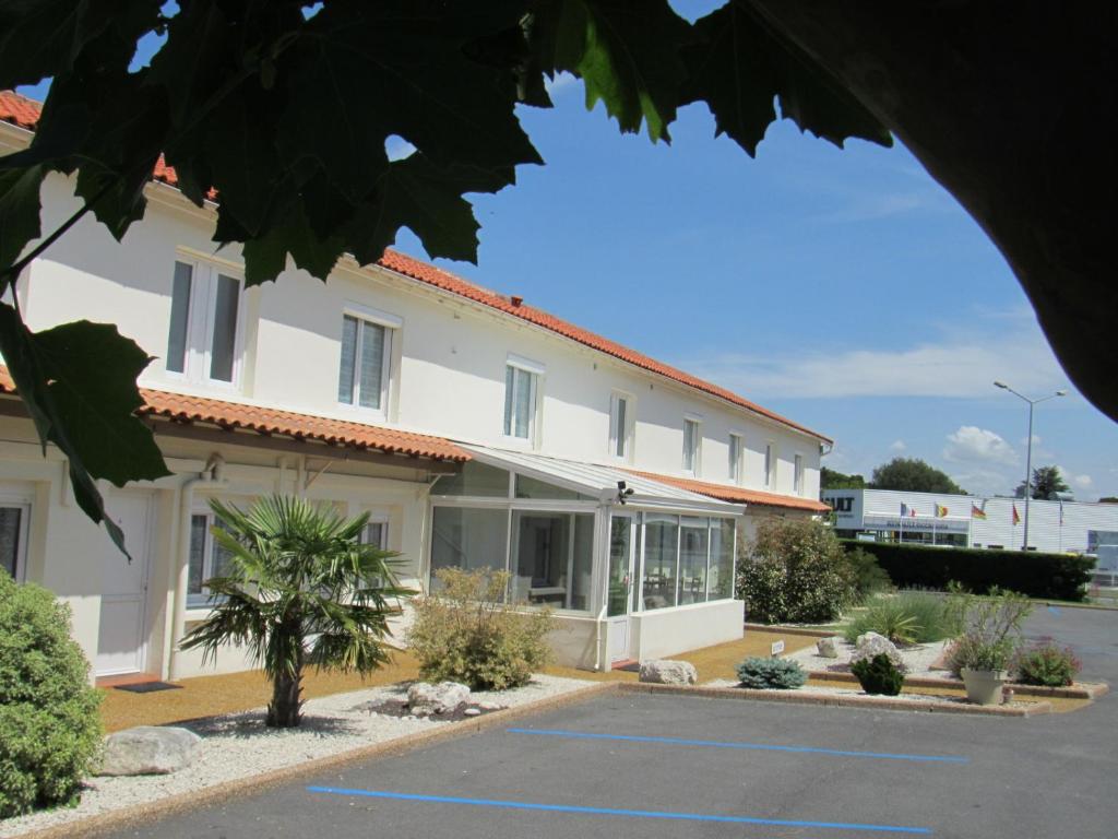 a large white building with a lot of windows at Cit'Hotel Les Atlantes in Médis