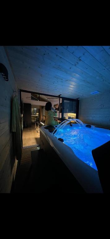 un homme dans une grande baignoire bleue dans une pièce dans l'établissement Les suites de Stanislas jacuzzi & spa, à Nancy