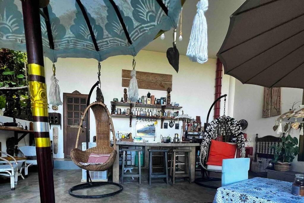 Valencia的住宿－ASRI Villas，一间设有酒吧、椅子和遮阳伞的房间