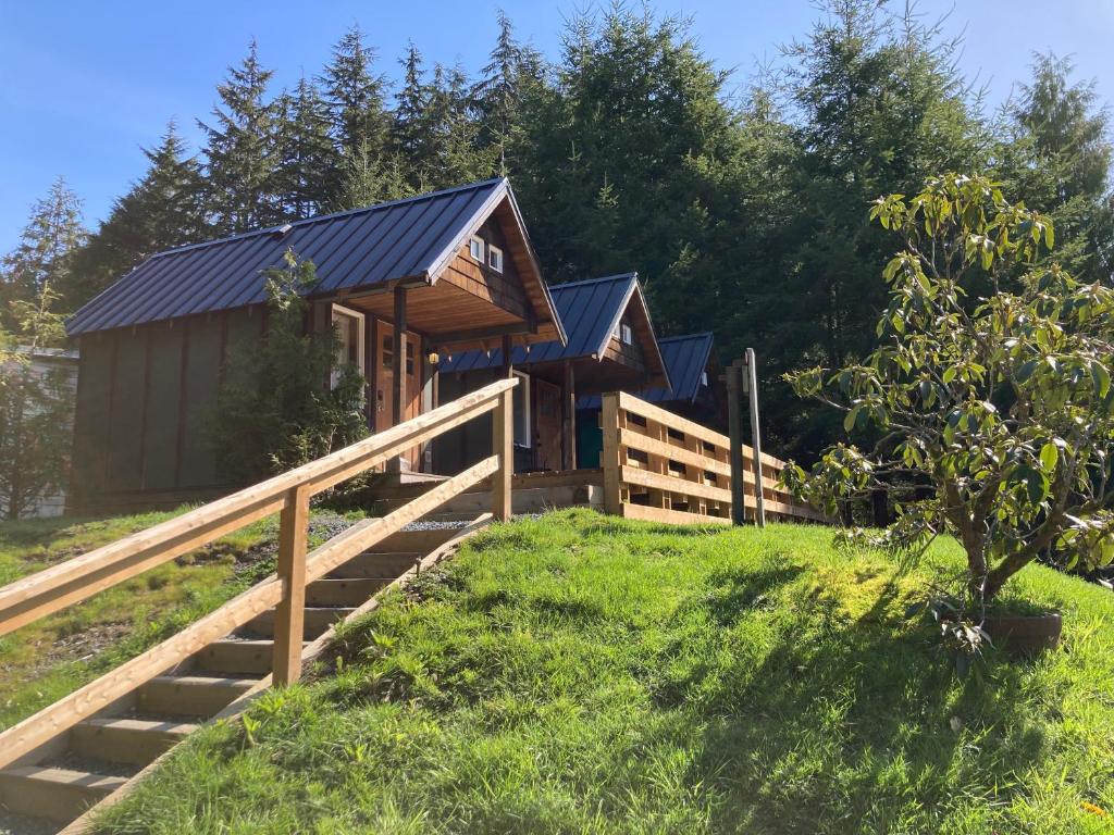 una cabaña en el bosque con una valla de madera en The Hiker Huts, en Port Renfrew