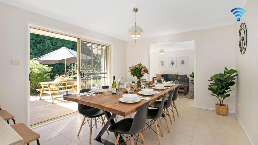 uma sala de jantar com uma grande mesa de madeira e cadeiras em Terra Bella em Robertson