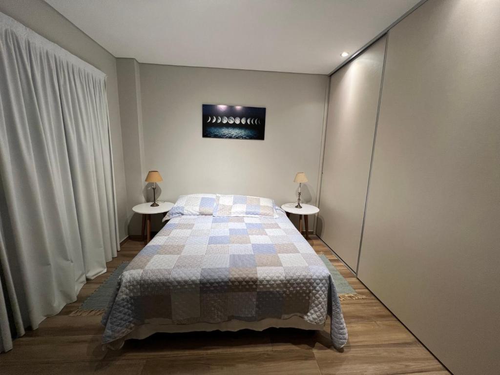 ein Schlafzimmer mit einem Bett und zwei Nachttischen in der Unterkunft Edificio El Arbol piso 2 in Corrientes