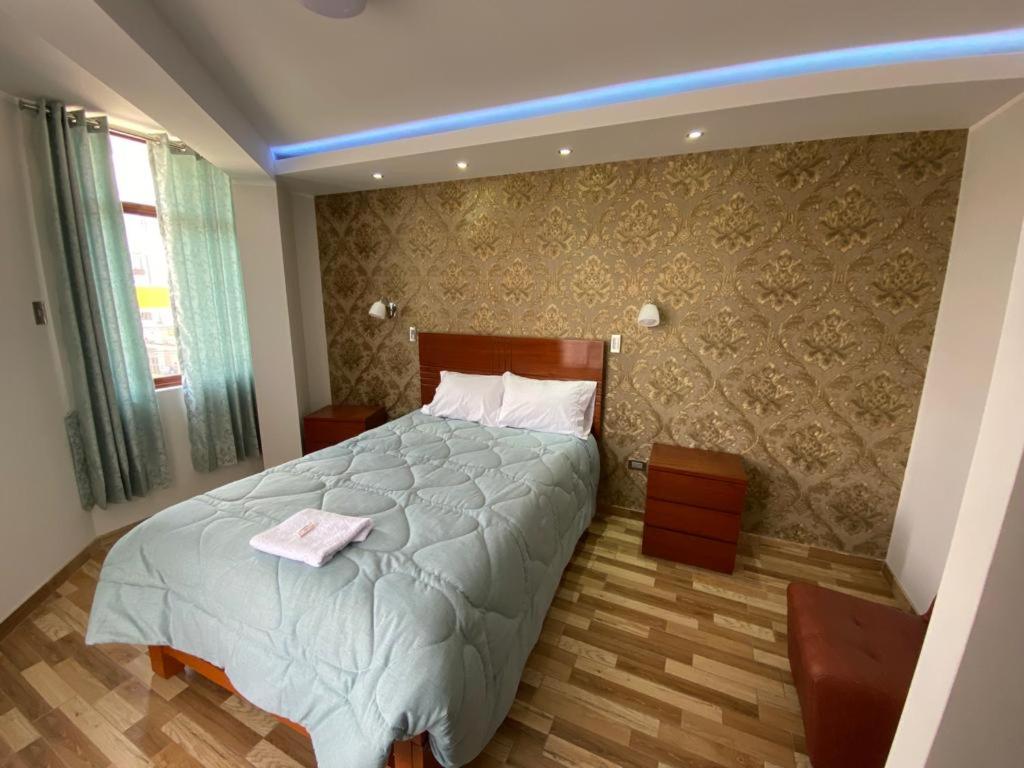 Un dormitorio con una cama con una toalla. en EL GRAN SEÑORIAL, en Jauja