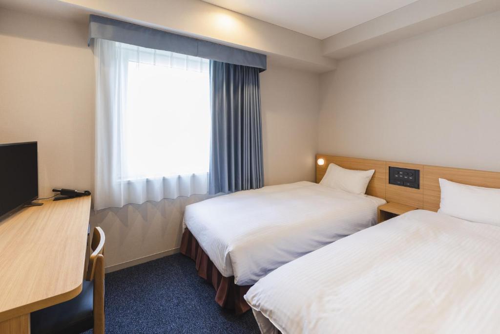 Postel nebo postele na pokoji v ubytování Sotetsu Fresa Inn Tokyo-Akasaka