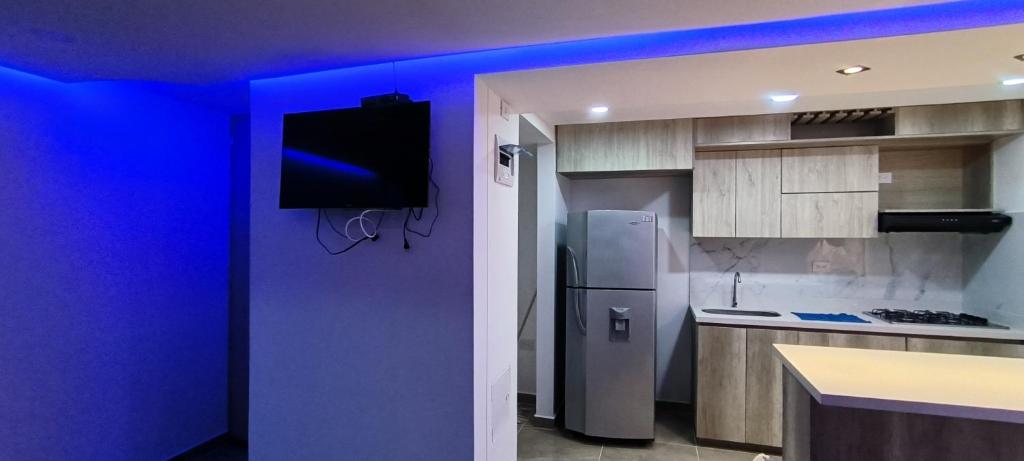 Il comprend une cuisine équipée d'un réfrigérateur et une télévision murale. dans l'établissement Apartamento Bello amazonia - Medellín, à Bello