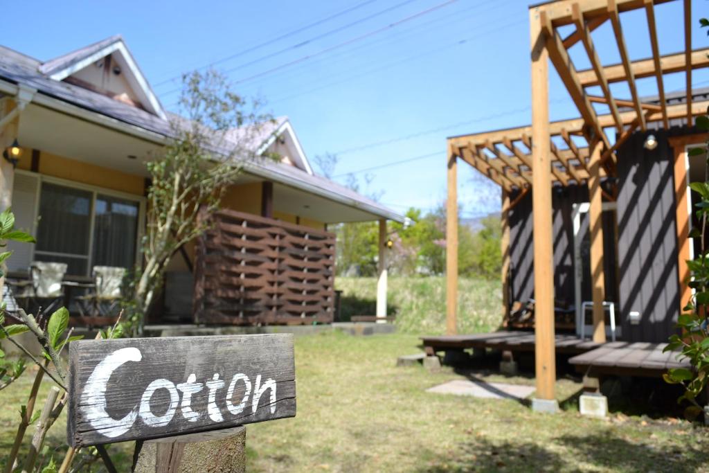 una señal frente a una casa en A private retreat Cotton Club Cottage, en Takamori