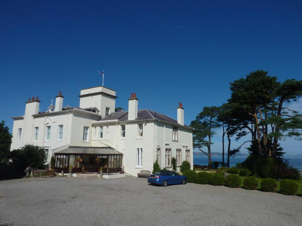 a large white house with a car parked in front of it at Invernairne in Nairn